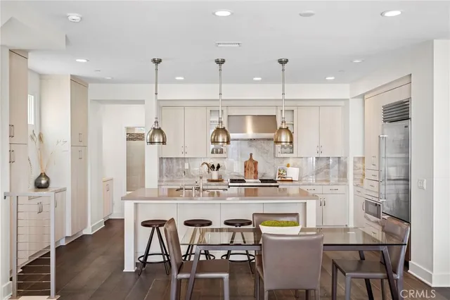 a kitchen with kitchen island granite countertop a sink and refrigerator