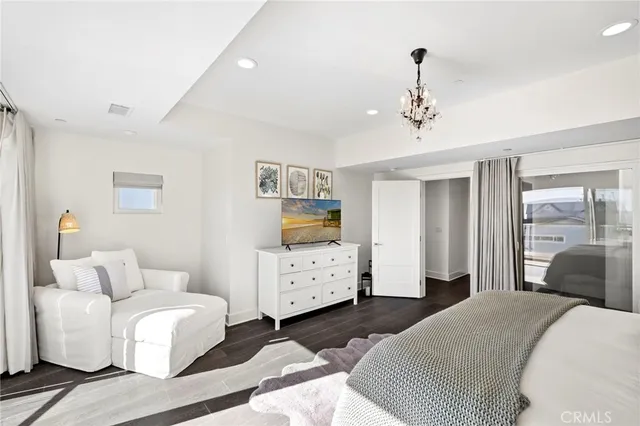 a bedroom with a white bed and ceiling fan