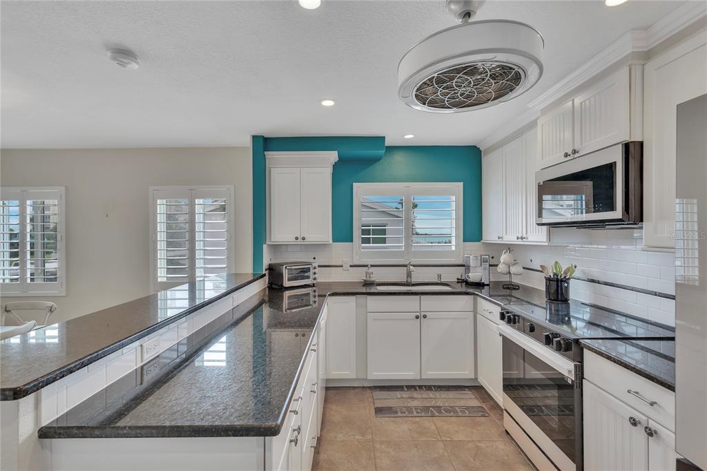 Undisclosed Address Clearwater, FL 33767 - Photo 15 of 39 a kitchen with stainless steel appliances granite countertop a sink a stove top oven a counter space and cabinets