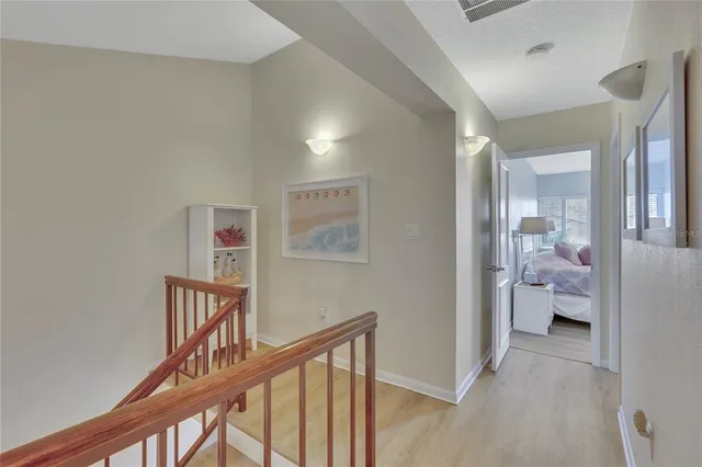 a view of a hallway with bathroom and wooden floor