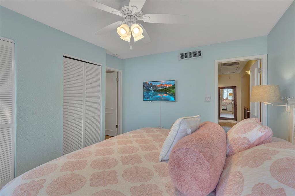 Undisclosed Address Clearwater, FL 33767 - Photo 24 of 39 a bedroom with a large bed and a chandelier