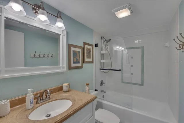 a bathroom with a granite countertop sink toilet and shower