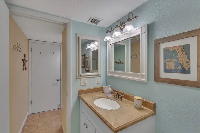 a bathroom with a granite countertop sink and a mirror