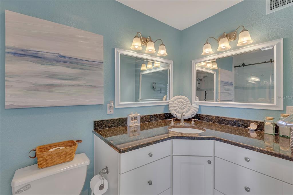 Undisclosed Address Clearwater, FL 33767 - Photo 34 of 39 a bathroom with a granite countertop sink a toilet and a mirror