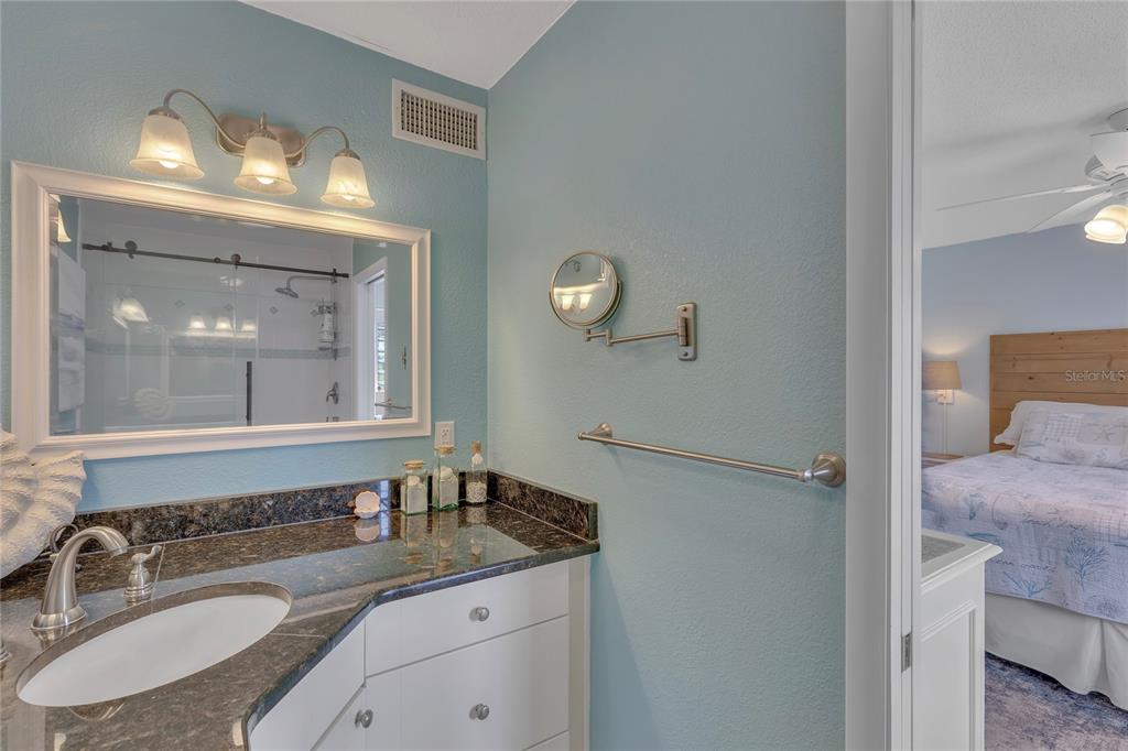 Undisclosed Address Clearwater, FL 33767 - Photo 36 of 39 a bathroom with a granite countertop sink a mirror and a shower