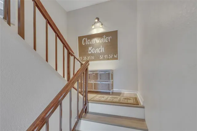 a view of staircase with railing and white walls