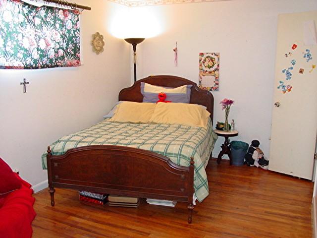 6115 Jameson Road Amarillo, TX 79106 - Photo 8 of 12 a bedroom with a bed and wooden floor