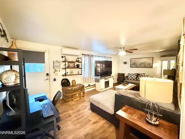 a living room with furniture a flat screen tv and a floor to ceiling window