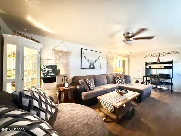 a living room with furniture ceiling fan and a large window