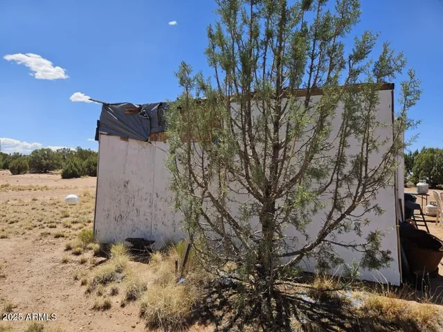 a view of a yard with wooden fence