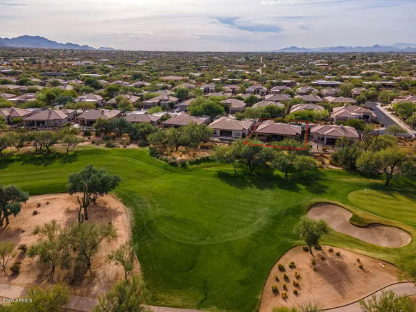 an aerial view of a house with a yard and lake view