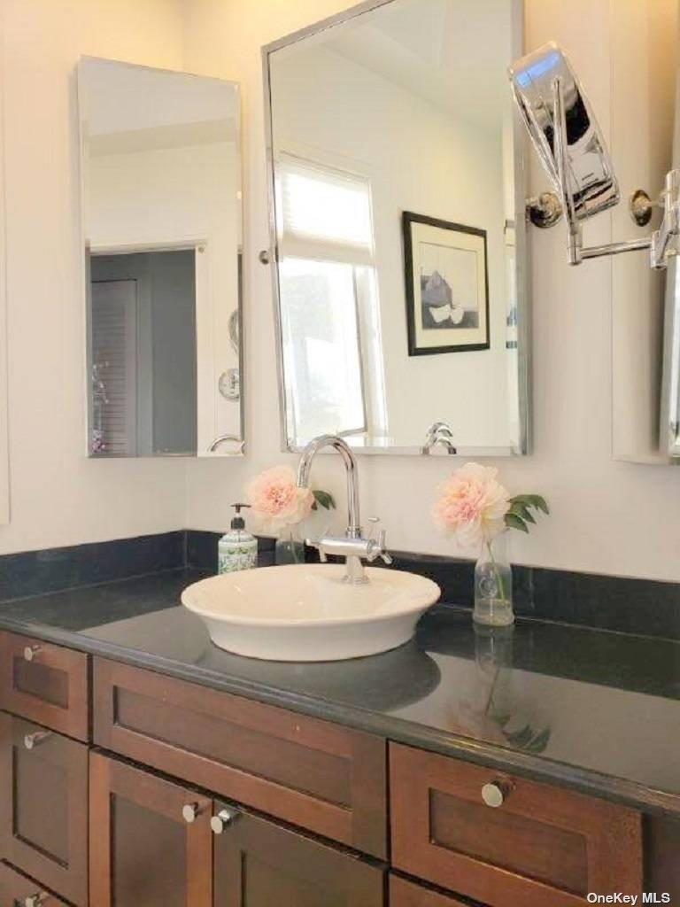 11 Beach Road Riverhead, NY 11947 - Photo 23 of 34 a bathroom with a sink and a mirror