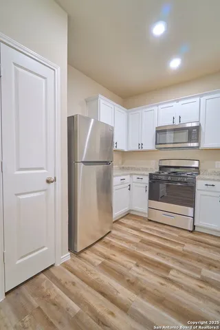 a kitchen with a refrigerator and a stove top oven