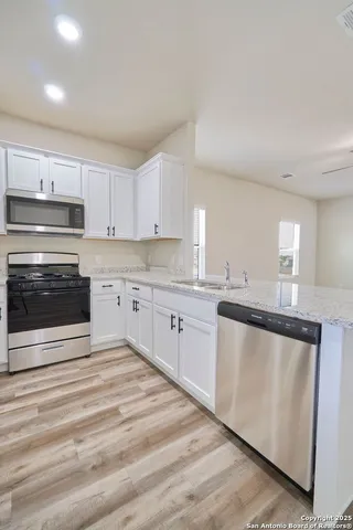 a kitchen with granite countertop white cabinets and white appliances
