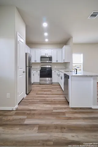 a kitchen with a refrigerator stove top oven and sink