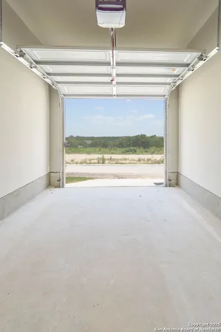 a view of a room with a floor to ceiling window and a ceiling fan