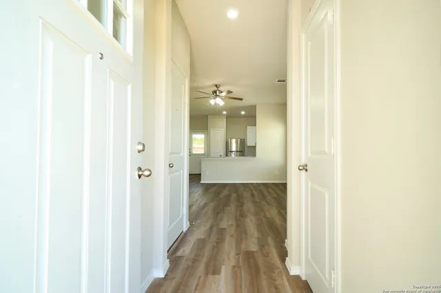 a view of a hallway with wooden floor