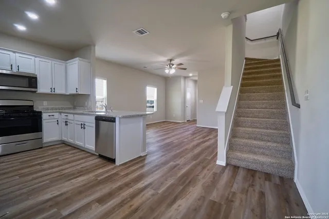 a view of a kitchen with wooden floor and electronic appliances