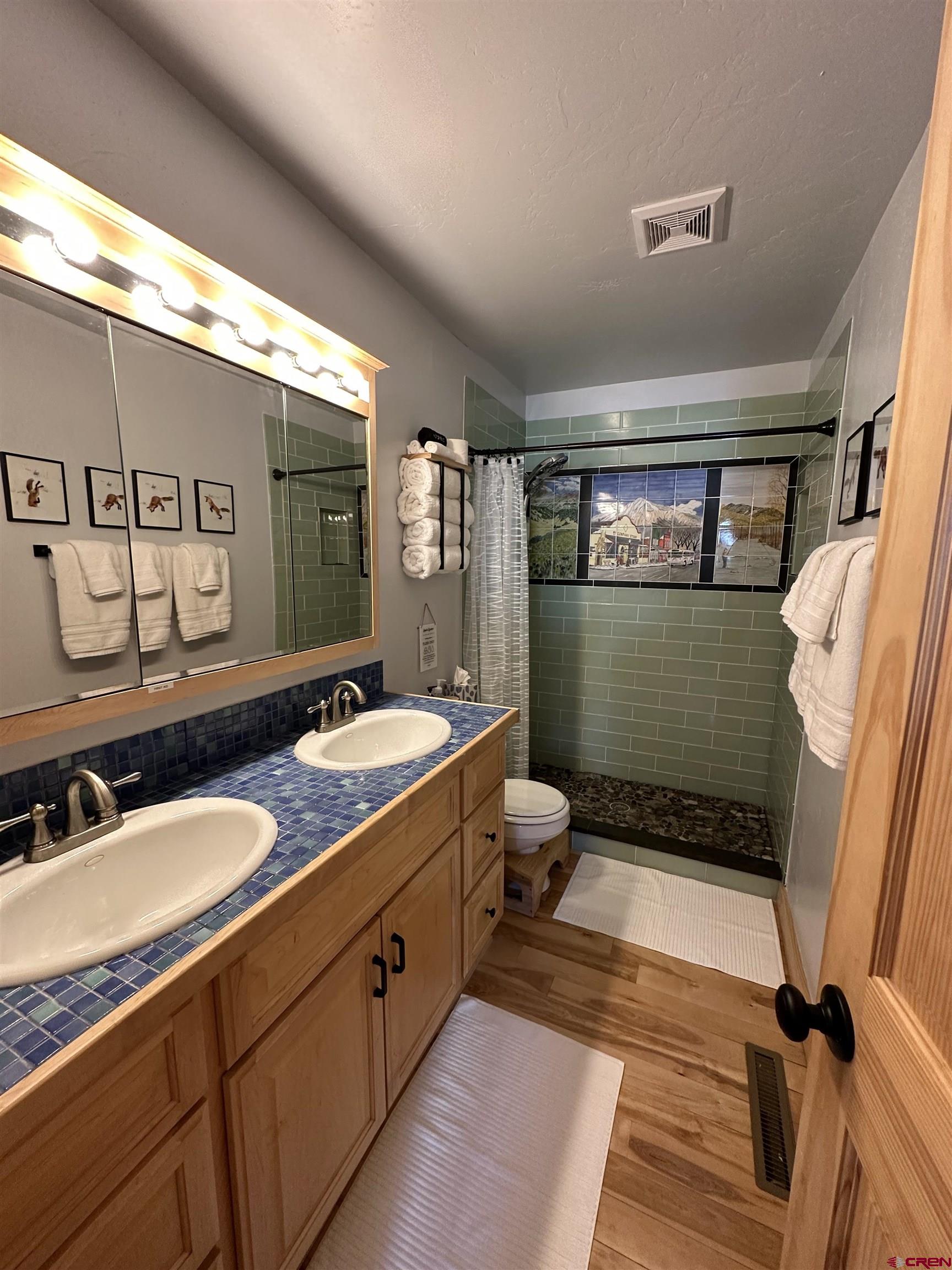 755 Gothic Road, Unit 2 Crested Butte, CO 81225 - Photo 22 of 36 a bathroom with a double vanity sink toilet mirror and tub