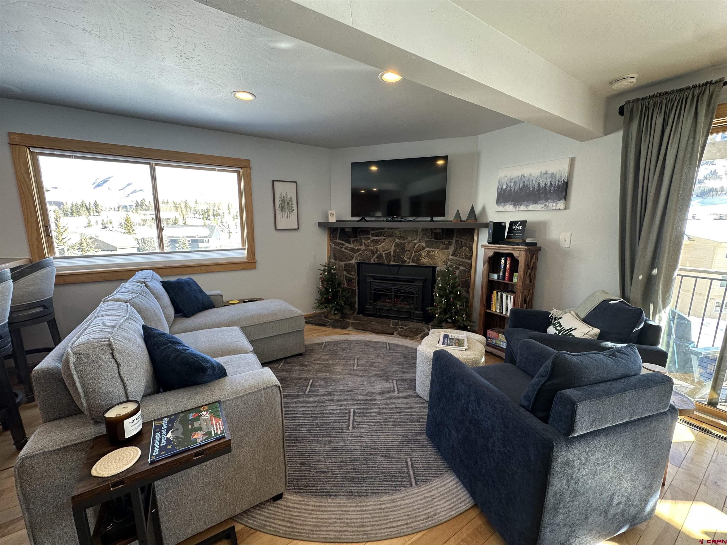 755 Gothic Road, Unit 2 Crested Butte, CO 81225 - Photo 5 of 36 a living room with furniture a flat screen tv and a fireplace