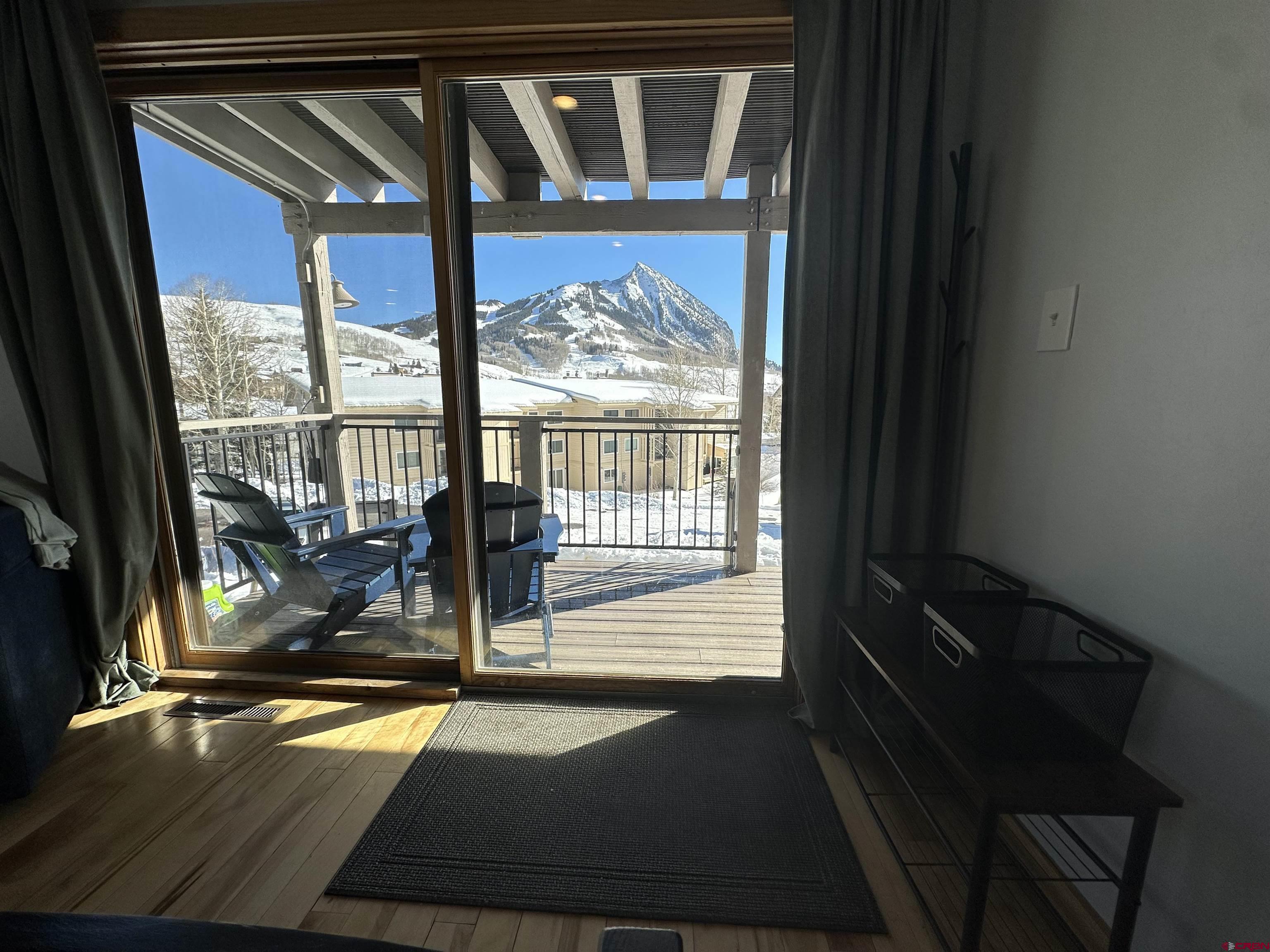 755 Gothic Road, Unit 2 Crested Butte, CO 81225 - Photo 5 of 36 a view of a two room with wooden floor and a floor to ceiling window