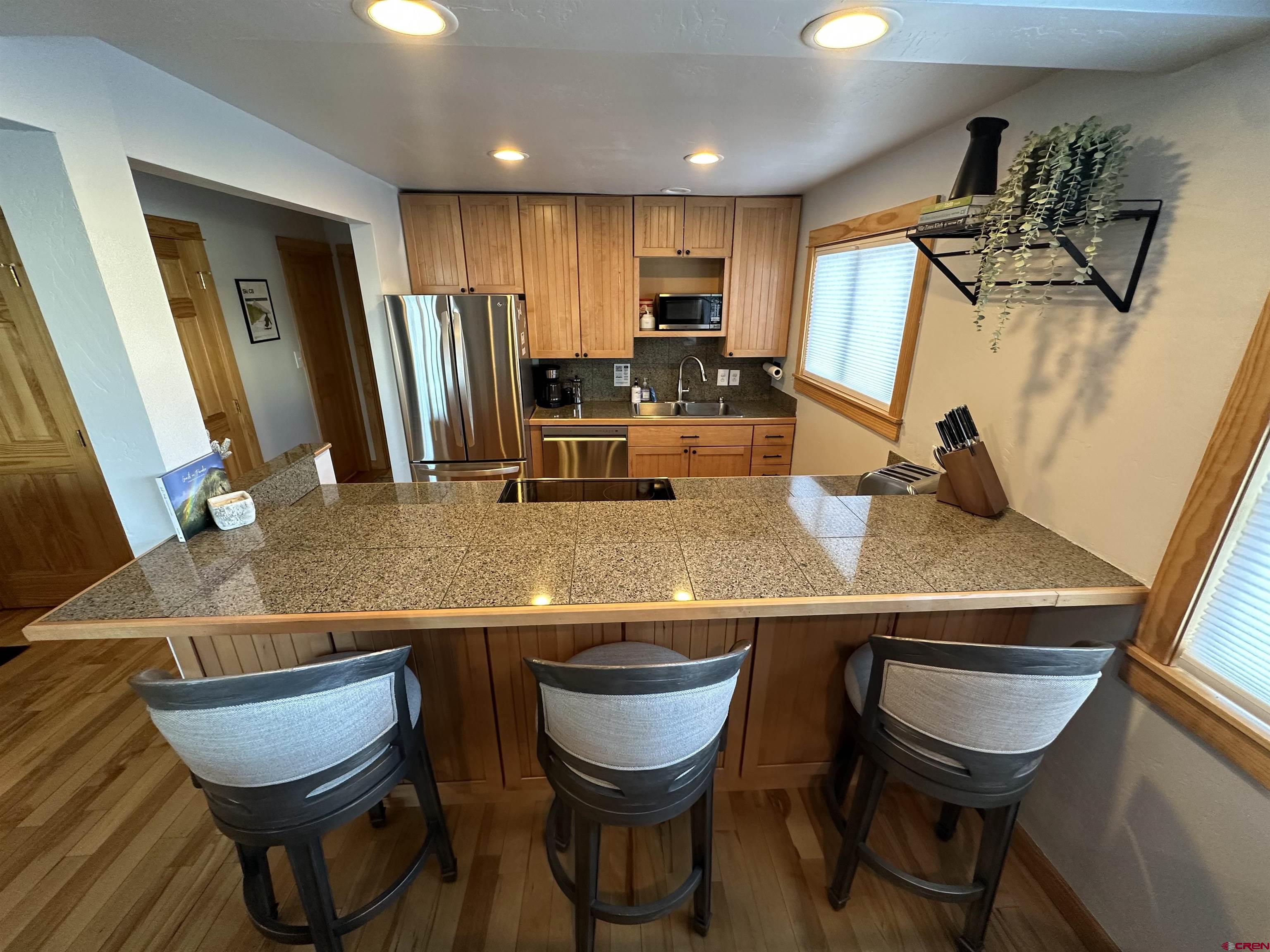 755 Gothic Road, Unit 2 Crested Butte, CO 81225 - Photo 10 of 36 a kitchen with stainless steel appliances a table chairs and a refrigerator