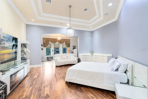 a bedroom with a bed wooden floor and a window