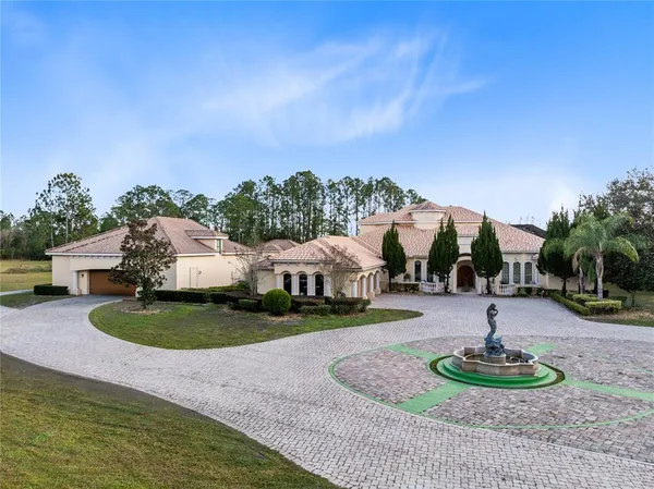 a view of a large house with a big yard and large trees