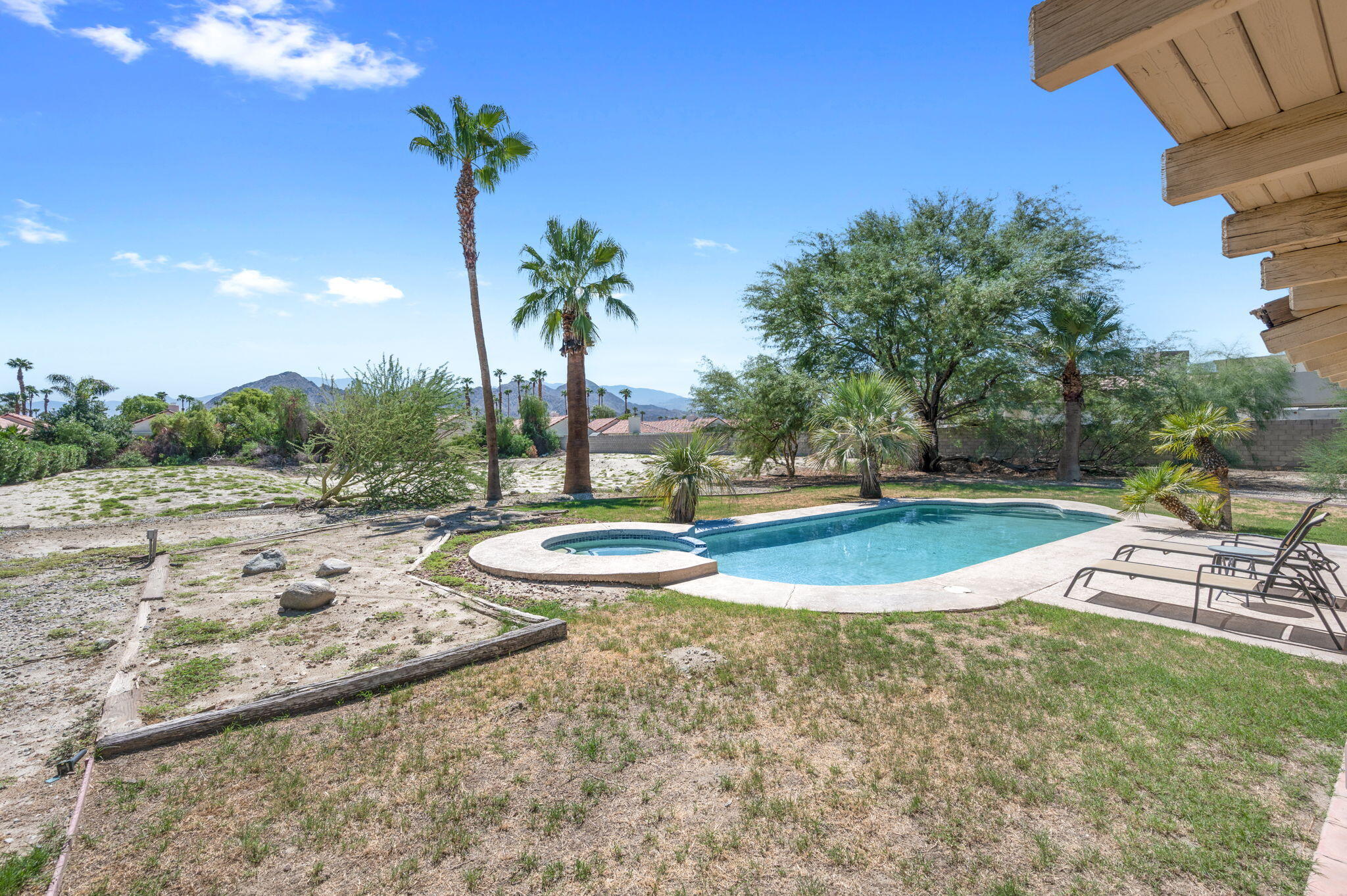 77725 Robin Road Palm Desert, CA 92211 - Photo 38 of 43 a view of a swimming pool with a yard