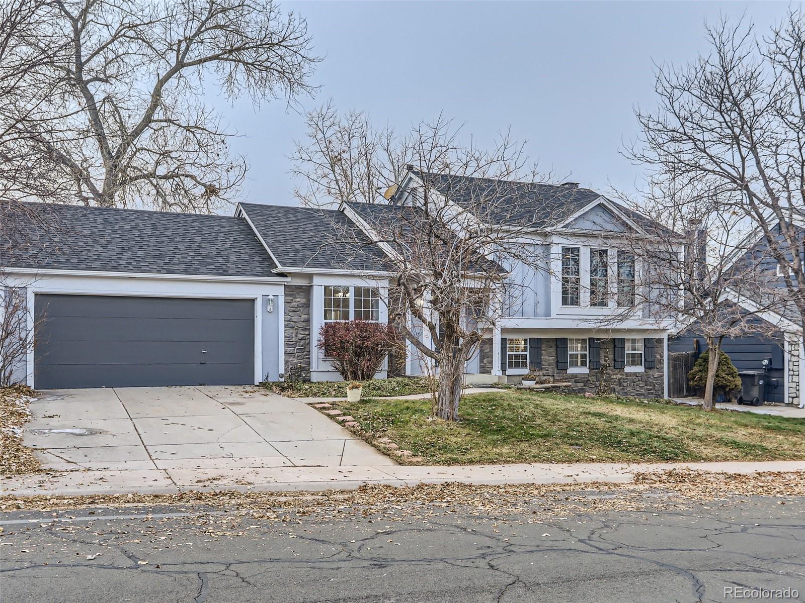 5941 South Perth Street Centennial, CO 80015 - Photo 1 of 28 a front view of a house with a yard and garage
