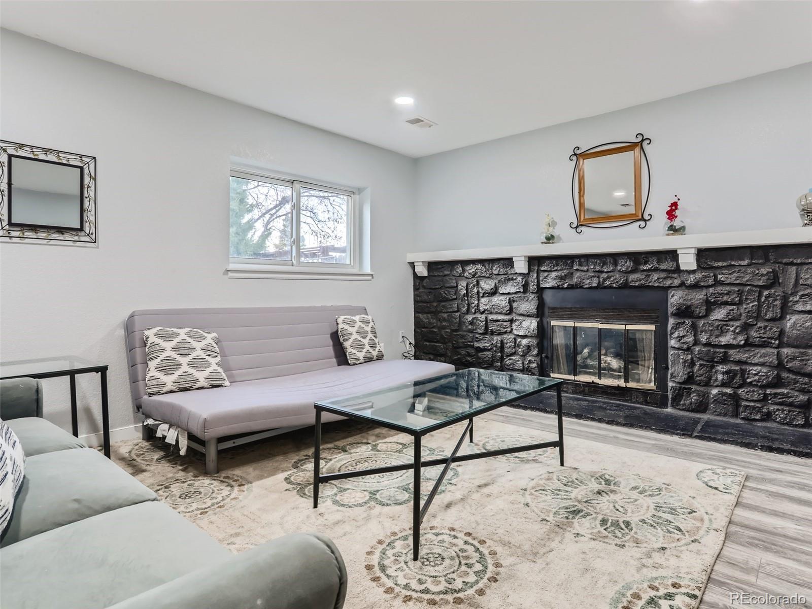 5941 South Perth Street Centennial, CO 80015 - Photo 12 of 28 a living room with furniture a rug and a fireplace