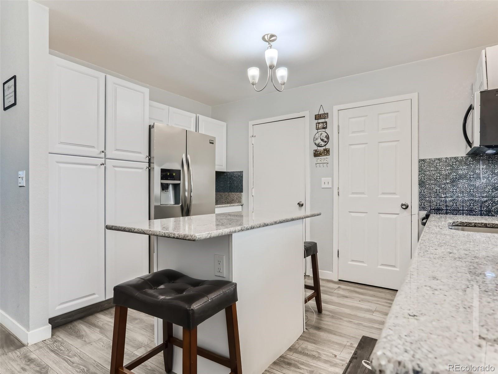 5941 South Perth Street Centennial, CO 80015 - Photo 10 of 28 a kitchen with stainless steel appliances a refrigerator and a stove top oven