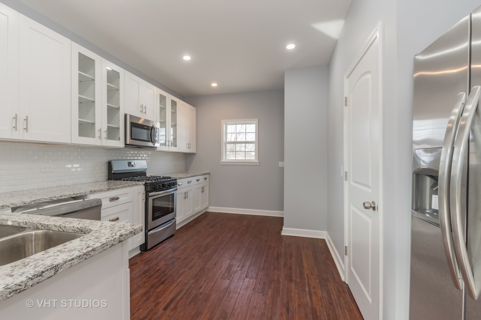 609 North Reed Street Joliet, IL 60435 - Photo 6 of 19 a large kitchen with stainless steel appliances granite countertop a refrigerator a sink dishwasher a stove and white countertops with wooden floor