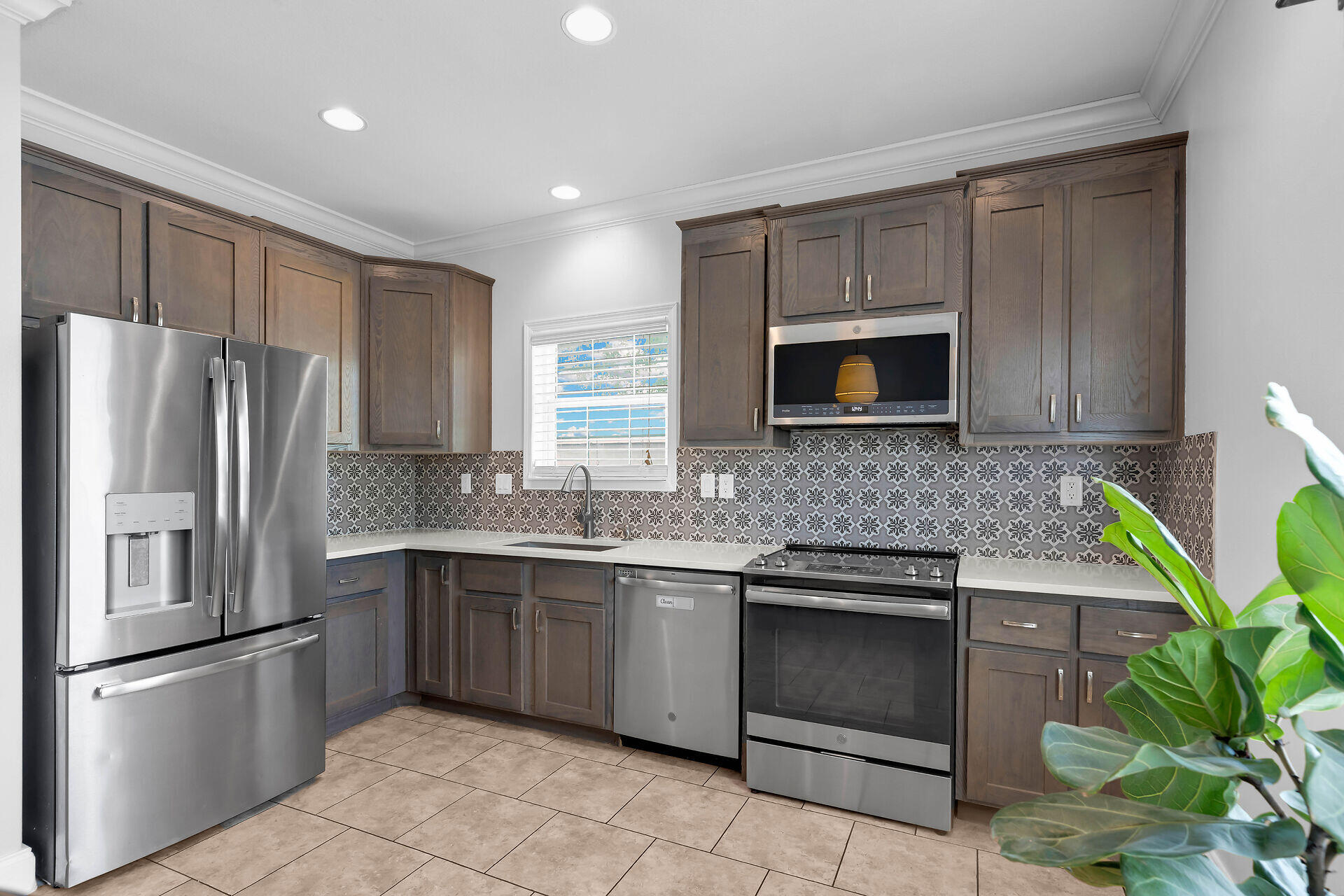 59 Ed Swift Road Key West, FL 33040 - Photo 11 of 35 a kitchen with stainless steel appliances granite countertop a refrigerator stove a sink and dishwasher