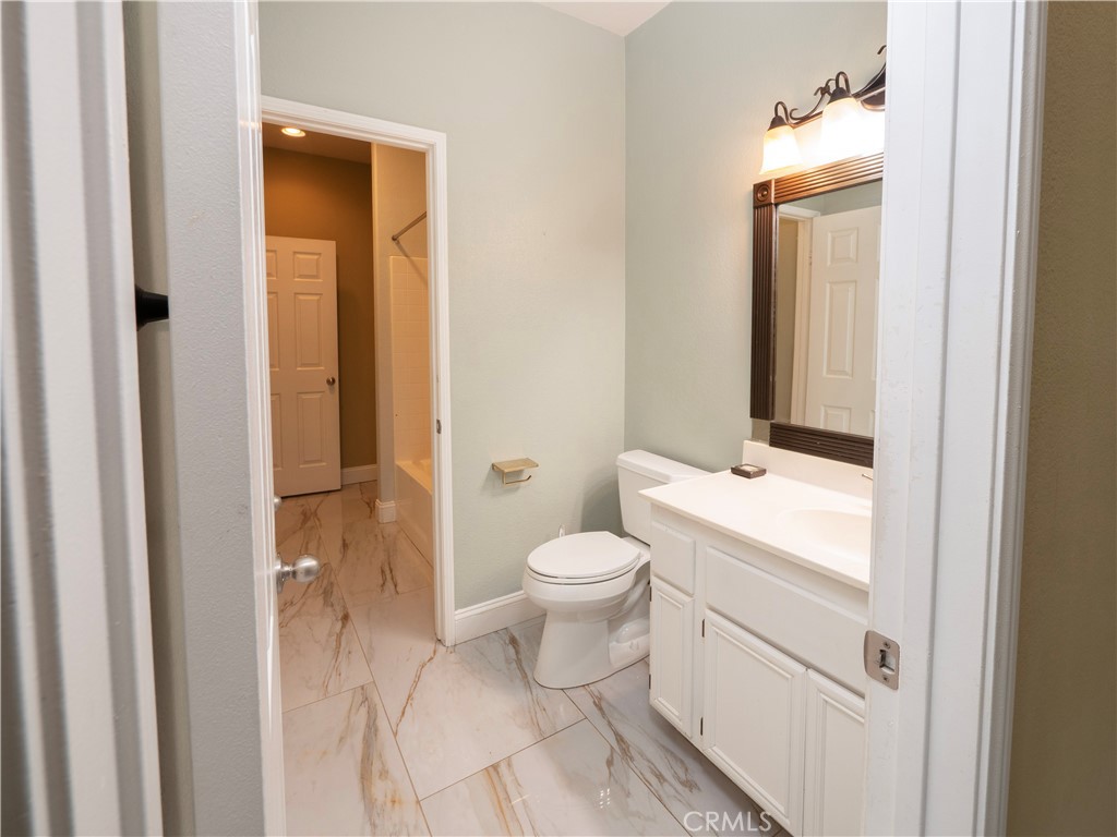 19128 Trail Ride Court Perris, CA 92570 - Photo 15 of 50 a bathroom with a toilet a sink and a mirror