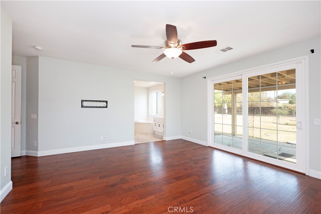 19128 Trail Ride Court Perris, CA 92570 - Photo 19 of 50 a view of an empty room with wooden floor and a window