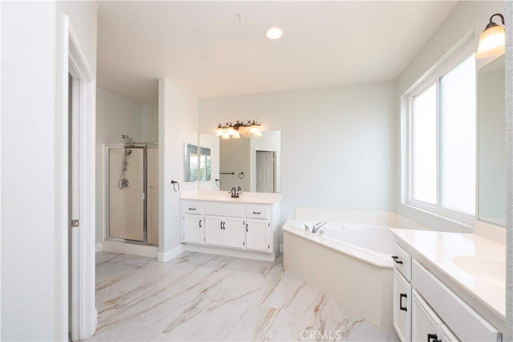19128 Trail Ride Court Perris, CA 92570 - Photo 20 of 50 a bathroom with a granite countertop sink mirror bathtub and next to a window