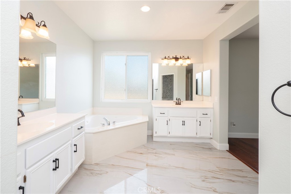 19128 Trail Ride Court Perris, CA 92570 - Photo 21 of 50 a spacious bathroom with a double vanity sink mirror and bathtub