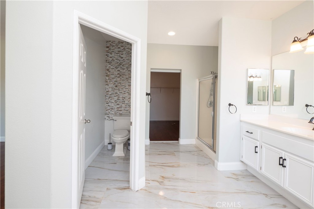 19128 Trail Ride Court Perris, CA 92570 - Photo 23 of 50 a bathroom with a double vanity sink toilet and shower