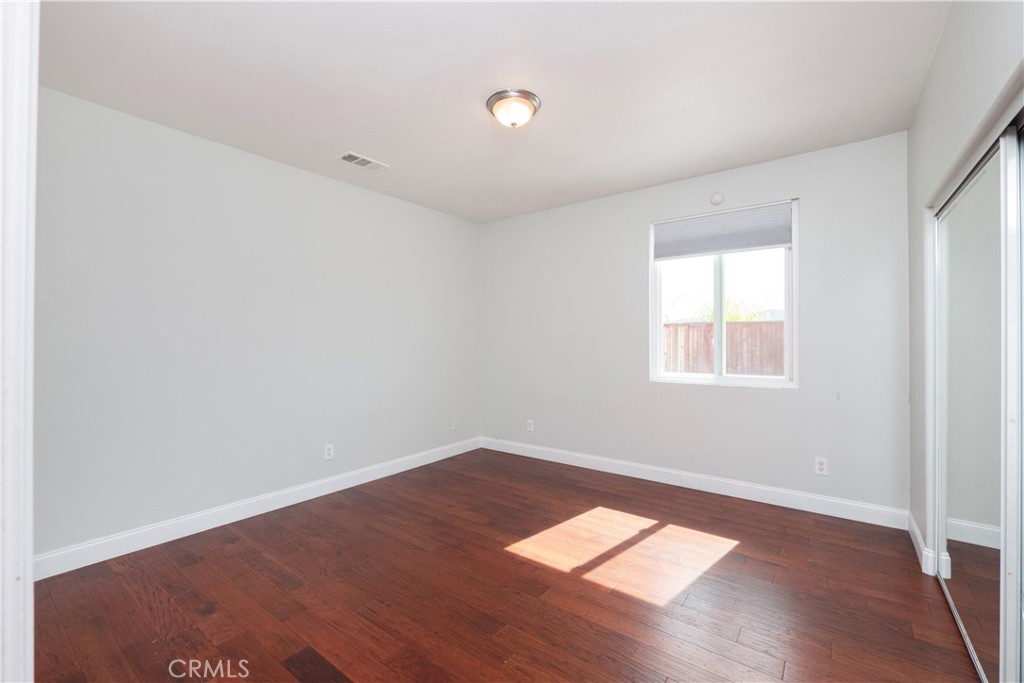 19128 Trail Ride Court Perris, CA 92570 - Photo 27 of 50 an empty room with wooden floor and windows