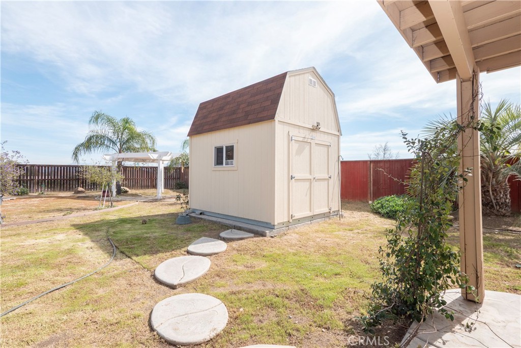 19128 Trail Ride Court Perris, CA 92570 - Photo 34 of 50 a view of a white house with a yard and potted plants