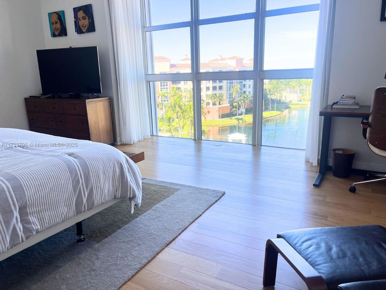 741 Crandon Boulevard, Unit PH4 Key Biscayne, FL 33149 - Photo 14 of 29 a bedroom with a bed and a flat tv screen on the dresser