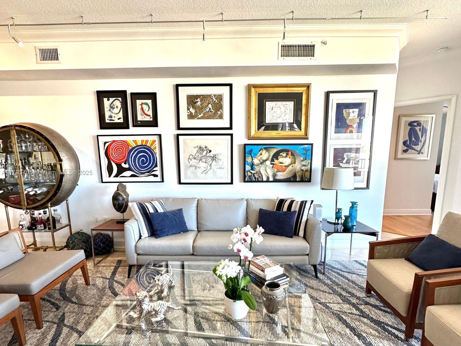 741 Crandon Boulevard, Unit PH4 Key Biscayne, FL 33149 - Photo 3 of 29 a living room with furniture and paintings on the wall