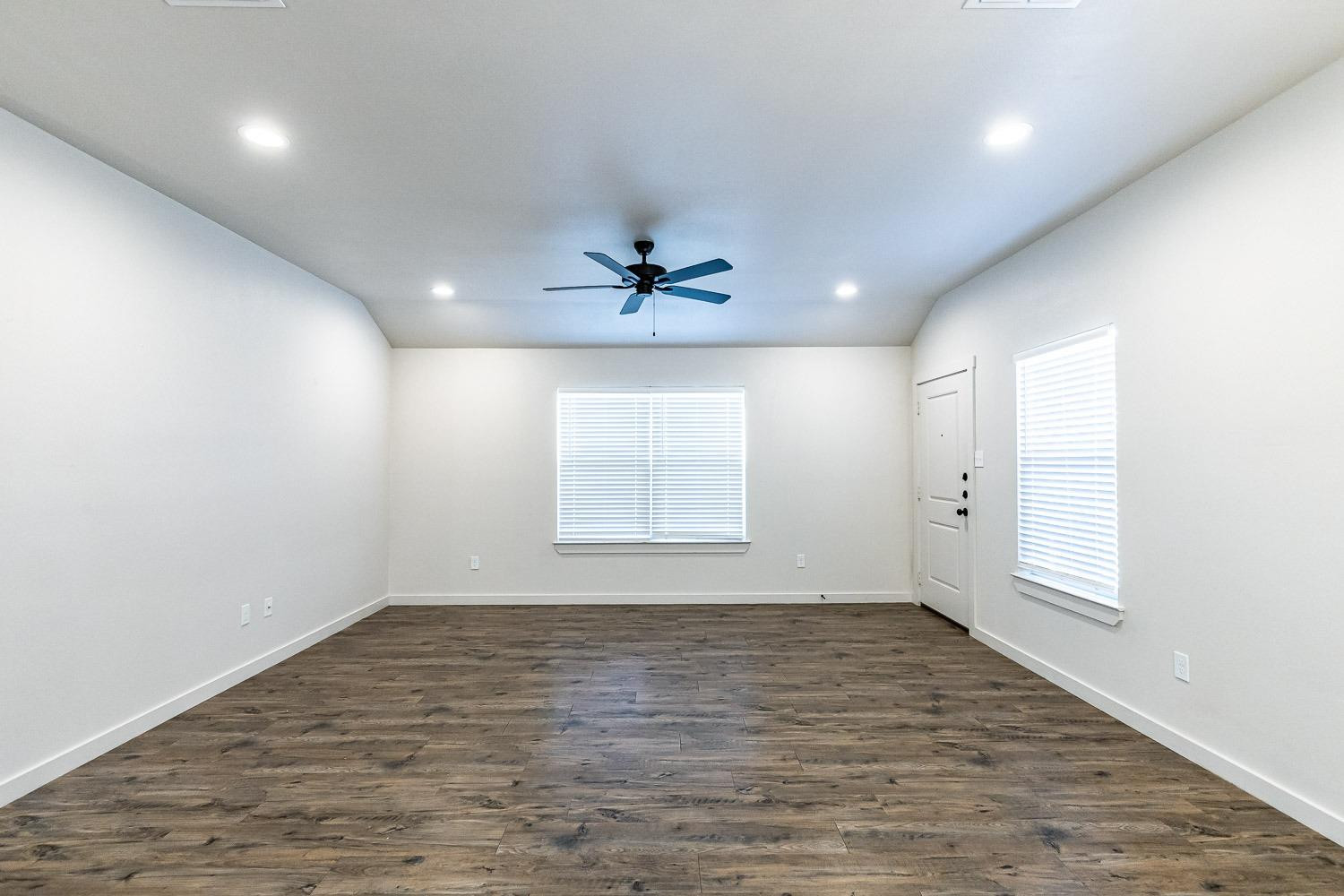 5517 121st Street, Unit B Lubbock, TX 79424 - Photo 11 of 37 wooden floor in an empty room with a window