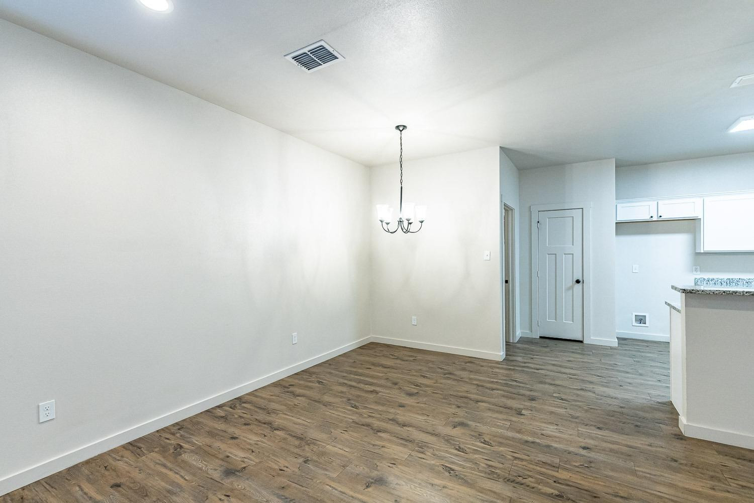 5517 121st Street, Unit B Lubbock, TX 79424 - Photo 12 of 37 a view of an empty room with wooden floor and a window