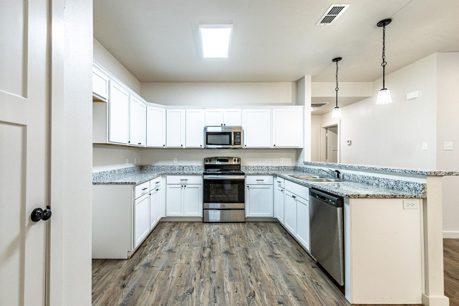 5517 121st Street, Unit B Lubbock, TX 79424 - Photo 17 of 37 a kitchen with granite countertop a sink and steel appliances