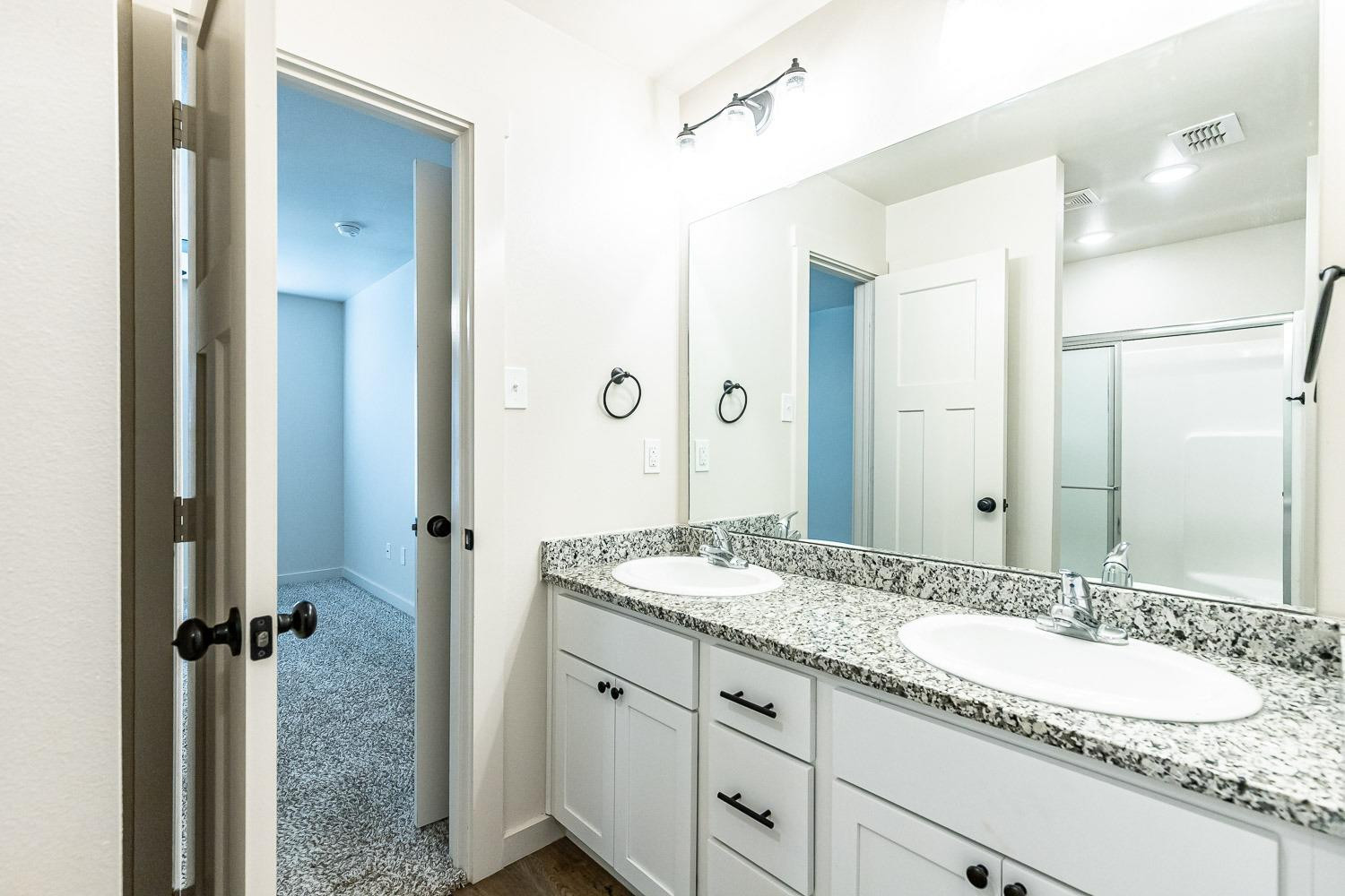 5517 121st Street, Unit B Lubbock, TX 79424 - Photo 26 of 37 a bathroom with a granite countertop sink mirror and double