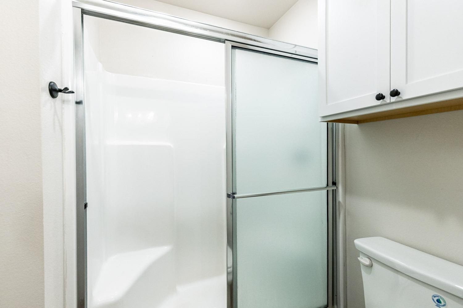 5517 121st Street, Unit B Lubbock, TX 79424 - Photo 27 of 37 a bathroom with a glass shower door