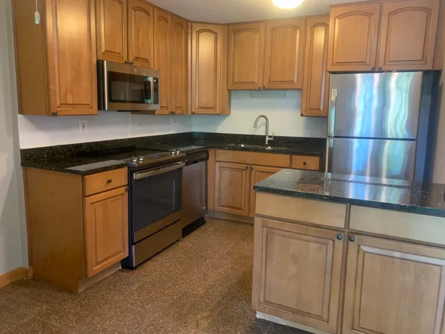 a kitchen with stainless steel appliances granite countertop a refrigerator stove a sink and dishwasher