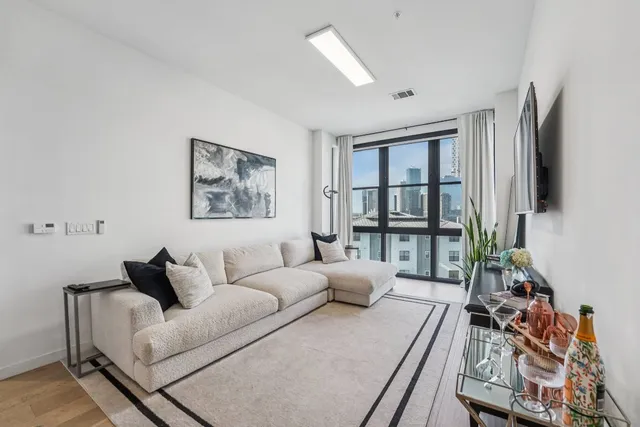 a living room with furniture large window and flat screen tv